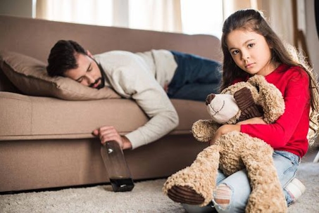 Father passed out drunk on the couch next to child
