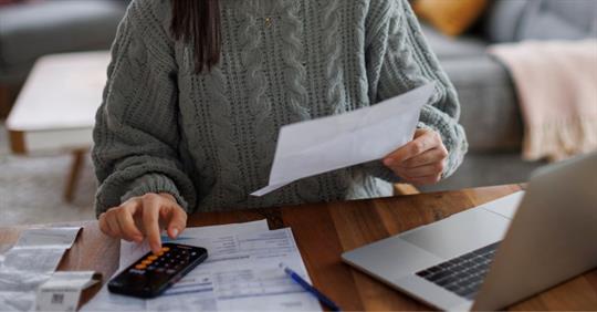 Woman checking her monthly expenses and statements at home.